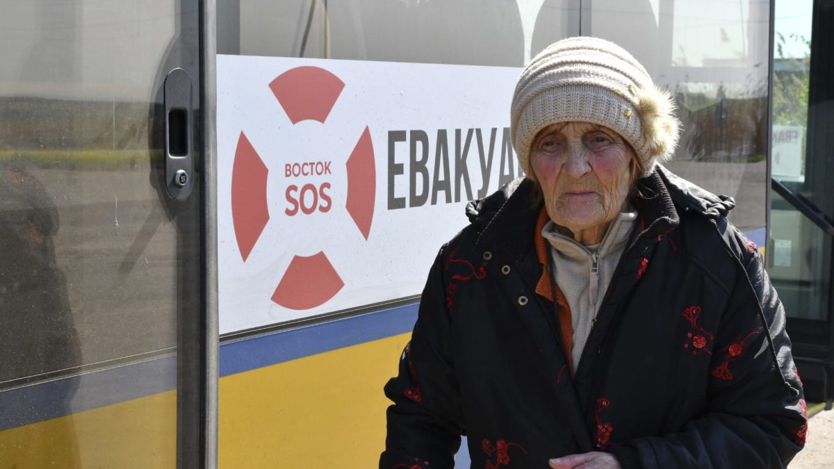 Una mujer espera para subir a un autobús durante la evacuación de civiles en una carretera cerca de Slovyansk, en el este de Ucrania, el 4 de mayo de 2022. (AP Photo/Andriy Andriyenko)