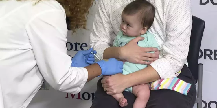 Ellen Fraint sostiene a su hija Jojo, de siete meses, mientras recibe la primera dosis de la vacuna Moderna COVID-19 en el Montefiore Medical Group de Nueva York el 21 de junio de 2022. (AP Photo/Ted Shaffrey)
