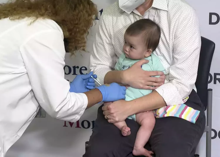 Ellen Fraint sostiene a su hija Jojo, de siete meses, mientras recibe la primera dosis de la vacuna Moderna COVID-19 en el Montefiore Medical Group de Nueva York el 21 de junio de 2022. (AP Photo/Ted Shaffrey)