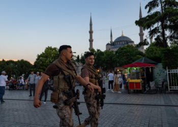Dos policías antidisturbios turcos caminan frente a la Mezquita Azul en Estambul, el 14 de junio de 2022. (Yasin Akgul/AFP)