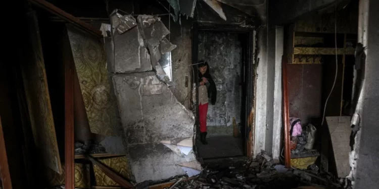 Archivo -- Maryna, de 59 años, frente a la puerta del piso dañado de sus vecinos en un edificio residencial de varios pisos tras el ataque ruso en la ciudad de Kherson, en el sur de Ucrania, el 7 de diciembre de 2022 (ANATOLII STEPANOV / AFP)