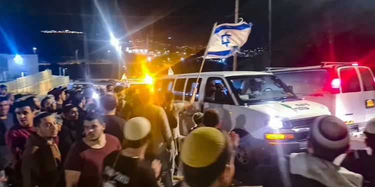 Sobreviviente de ataque pasa por Huwara con banderas israelíes