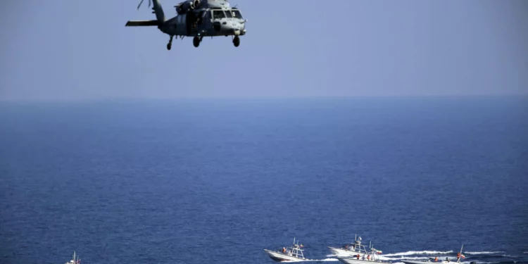 Un helicóptero estadounidense MH-60 Seahawk sobrevuela las patrullas de botes de la Guardia Revolucionaria iraní en el Estrecho de Hormuz el 21 de diciembre de 2018. (Jon Gambrell/AP)