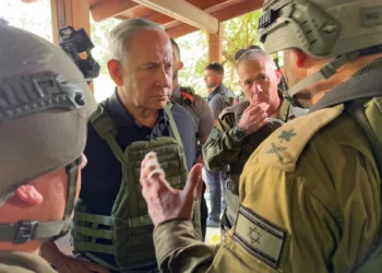 El primer ministro Benjamin Netanyahu (izq.) habla con oficiales de las FDI en una de las comunidades afectadas por el mortal ataque de Hamás, el 14 de octubre de 2023 (Avi Ohayon/GPO)