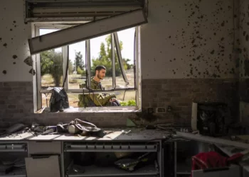 Un soldado israelí patrulla junto a una casa dañada por terroristas de Hamás en el kibutz Kissufim, en el sur de Israel, el 21 de octubre de 2023. (AP/Francisco Seco)