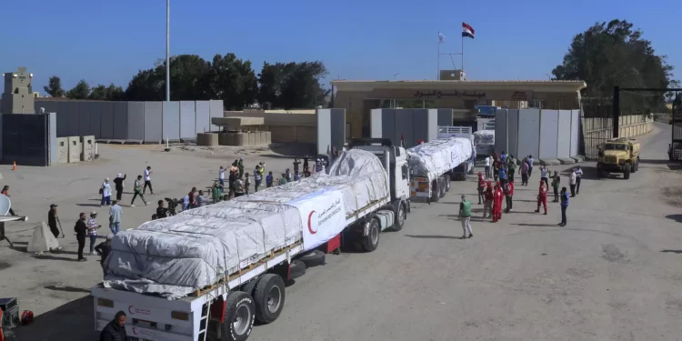 Camiones de la Media Luna Roja egipcia que transportan ayuda humanitaria para la Franja de Gaza cruzan la puerta fronteriza de Rafah, en Rafah, Egipto, el sábado 21 de octubre de 2023. (AP Photo/Mohammed Asad)