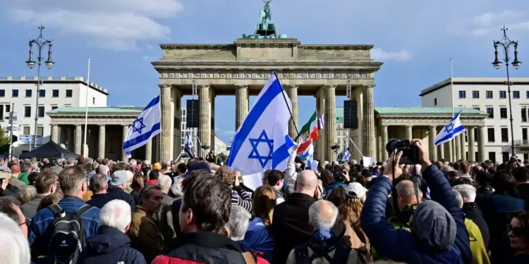 Manifestantes muestran banderas israelíes mientras asisten a una concentración en solidaridad con Israel en Berlín, 22 de octubre de 2023. (John MACDOUGALL / AFP)