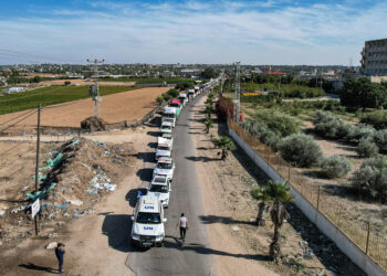 This aerial view shows humanitarian aid trucks arriving from Egypt after having crossed through the Rafah border crossing arriving at a storage facility in Khan Yunis in the southern Gaza Strip on October 21, 2023. - The first aid trucks arrived in war-torn Gaza from Egypt on October 21, bringing urgent humanitarian relief to the Hamas-controlled Palestinian enclave suffering what the UN chief labelled a "godawful nightmare". Israel has vowed to destroy Hamas after the Islamist militant group carried out the deadliest attack in the country's history on October 7. (Photo by Belal Al SABBAGH / AFP)