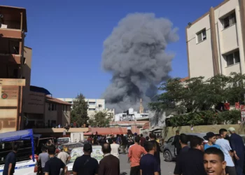 Varias personas observan el humo y el polvo tras un bombardeo israelí en Khan Younis, en el sur de la Franja de Gaza, el 26 de octubre de 2023. (Mahmud HAMS / AFP)