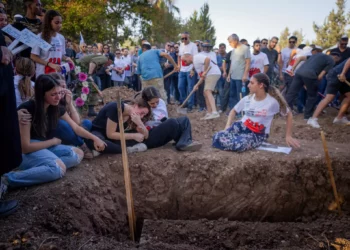 Familiares y amigos asisten al funeral de tres miembros de la familia Sharabi, Lian, Noya y Yahel, asesinados por terroristas de Hamás en el kibutz Be'eri el 7 de octubre de 2023, en Moshav Kfar HaRif, al sur de Israel, el 25 de octubre de 2023. (Chaim Goldberg/Flash90)