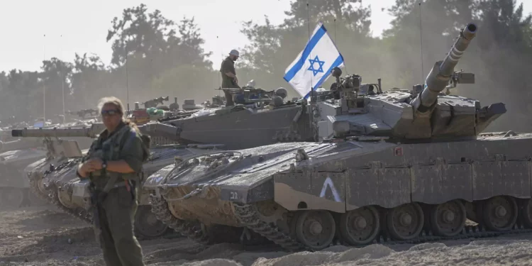 Soldados israelíes trabajan en un tanque en una zona de preparación cerca de la frontera con la Franja de Gaza, en el sur de Israel, 20 de octubre de 2023. (AP Photo/ Ohad Zwigenberg)