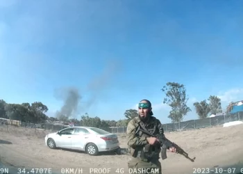 Una captura de un vídeo UGC publicado en Telegram el 9 de octubre de 2023 muestra a un terrorista palestino armado caminando por el festival de música Supernova, con un cuerpo detrás de él, cerca del Kibbutz Reim en el desierto de Negev en el sur de Israel (ANÓNIMO / AFP)