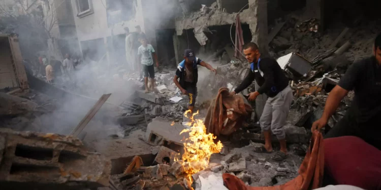 Varias personas buscan víctimas y supervivientes tras un ataque israelí contra la ciudad de Deir Al-Balah, en el centro de la Franja de Gaza, el 18 de octubre de 2023. (Mohammed Faiq / AFP)