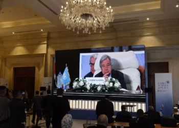 Periodistas observan una gran pantalla en la que se ve al Secretario General de las Naciones Unidas, Antonio Guterres, asistiendo a la Cumbre Internacional por la Paz organizada por el presidente egipcio en El Cairo el 21 de octubre de 2023. (Khaled Desouki/AFP)