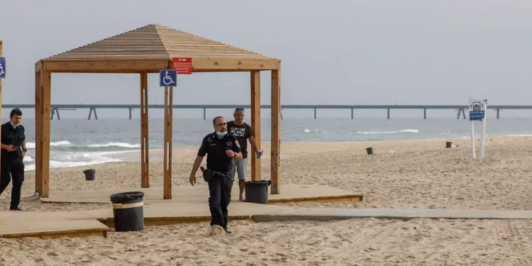 Agentes de policía israelíes caminan por la playa de Zikim, cerca de la frontera con Gaza, tras su cierre a los visitantes, el 24 de abril de 2021. (Flash90)