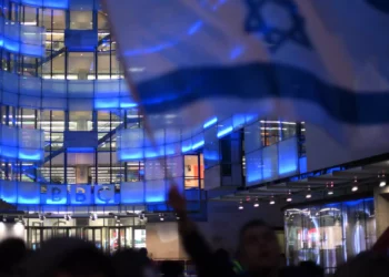 Manifestantes ondean banderas israelíes en una concentración ante la sede de la BBC en Londres el 16 de octubre de 2023, denunciando a la corporación por no referirse a Hamás como grupo terrorista. (Daniel LEAL / AFP)