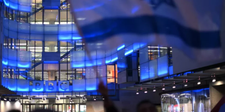 Manifestantes ondean banderas israelíes en una concentración ante la sede de la BBC en Londres el 16 de octubre de 2023, denunciando a la corporación por no referirse a Hamás como grupo terrorista. (Daniel LEAL / AFP)