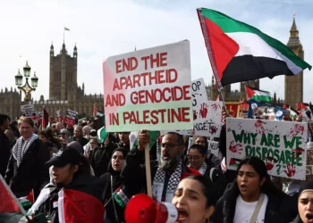 Manifestantes sostienen pancartas y ondean banderas palestinas durante una "Marcha por Palestina" en Londres el 28 de octubre de 2023, mientras piden un alto el fuego en la guerra entre Israel y Hamás. (Henry Nicholls/AFP)