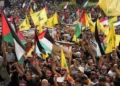 Seguidores de Hezbolá ondean banderas libanesas, palestinas y de su grupo, mientras sostienen pancartas a favor de Gaza durante una protesta para mostrar su solidaridad con los palestinos, en el suburbio sur de Beirut, Líbano, viernes 13 de octubre de 2023. (AP Photo/Hussein Malla)