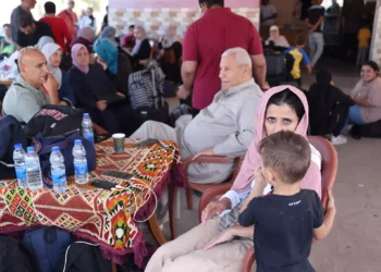 Palestinos con doble nacionalidad esperan fuera del paso fronterizo de Rafah con Egipto el 21 de octubre de 2023, mientras esperan permiso para cruzar. (Fotografía de MOHAMMED ABED / AFP)