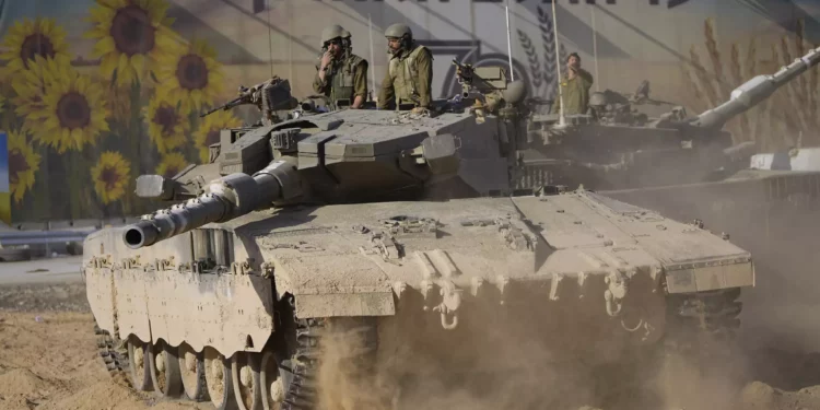 Soldados israelíes mueven un tanque en una zona de reagrupamiento cerca de la frontera con la Franja de Gaza, en el sur de Israel, el 15 de octubre de 2023. (AP Photo/Ohad Zwigenberg)