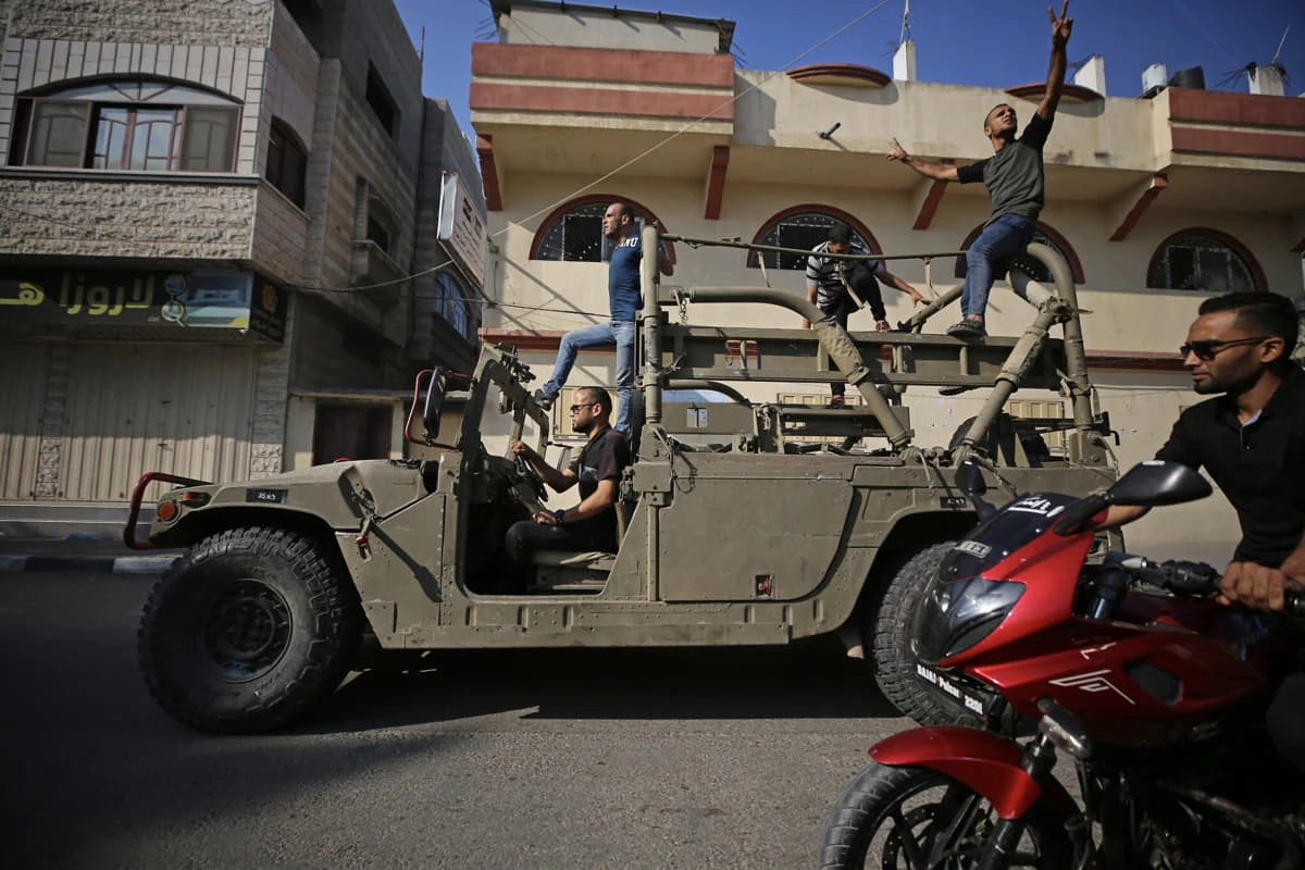 Los palestinos regresan a la ciudad de Gaza conduciendo un Humvee israelí que fue incautado después de que los terroristas ingresaron a Israel por tierra el 7 de octubre de 2023. (Foto de MAJDI FATHI / AFP)
