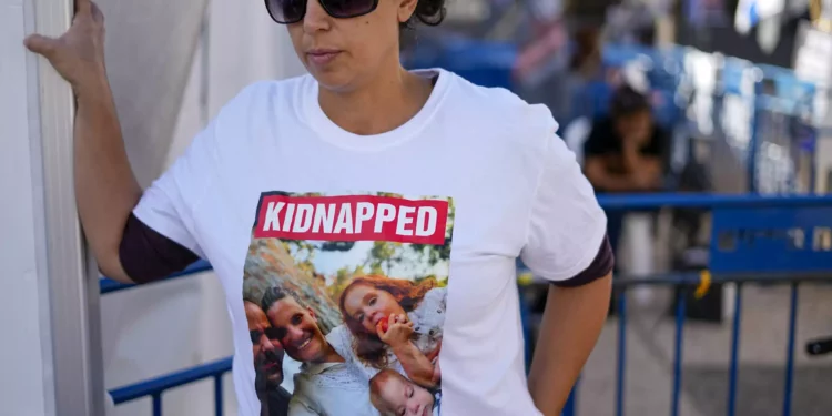 Ofri Bibas lleva una camiseta con una foto de su hermano, su cuñada y sus dos hijos, de 4 y 10 meses, secuestrados en Gaza, en Tel Aviv, el 21 de noviembre de 2023. (AP/Ariel Schalit)