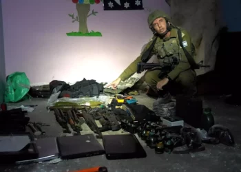 El portavoz de las FDI, Daniel Hagari, con las armas encontradas por las fuerzas de las FDI en un centro de mando de Hamás bajo el hospital Rantisi de la ciudad de Gaza, en una foto difundida por el ejército el 13 de noviembre de 2023. (Fuerzas de Defensa de Israel)