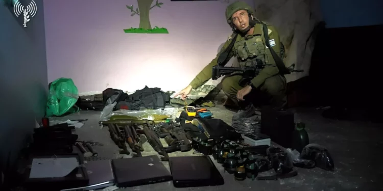 El portavoz de las FDI, Daniel Hagari, con las armas encontradas por las fuerzas de las FDI en un centro de mando de Hamás bajo el hospital Rantisi de la ciudad de Gaza, en una foto difundida por el ejército el 13 de noviembre de 2023. (Fuerzas de Defensa de Israel)