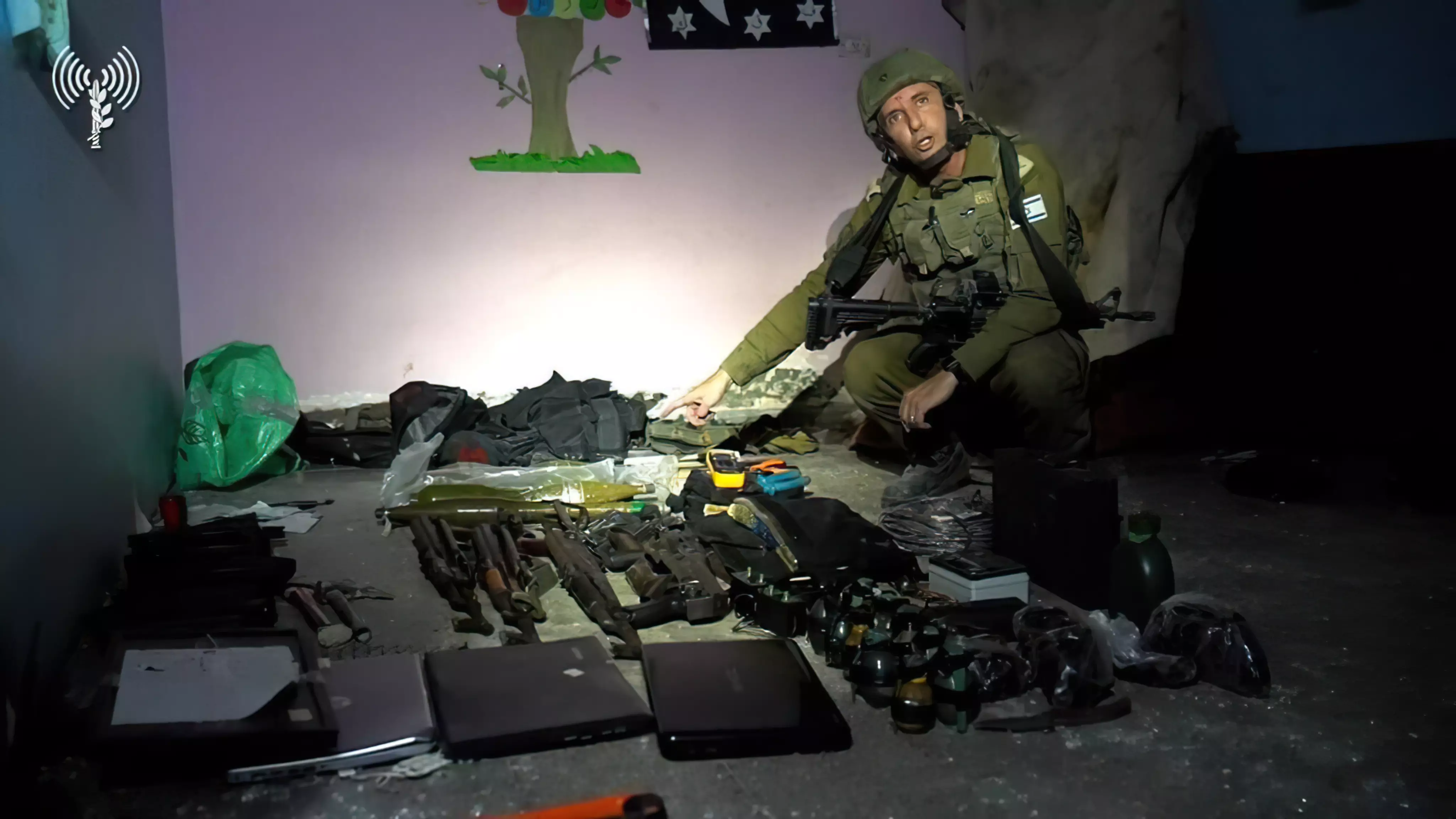 El portavoz de las FDI, Daniel Hagari, con las armas encontradas por las fuerzas de las FDI en un centro de mando de Hamás bajo el hospital Rantisi de la ciudad de Gaza, en una foto difundida por el ejército el 13 de noviembre de 2023. (Fuerzas de Defensa de Israel)