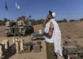 Covered in a prayer shawl, an Israeli soldier prays at an artillery position, near the Israeli-Gaza border, Israel, Monday, Nov. 06, 2023. (AP Photo/Ohad Zwigenberg)