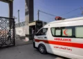 Ambulancias del Ministerio de Sanidad palestino cruzan la puerta para entrar en el paso fronterizo de Rafah, en el sur de la Franja de Gaza, antes de cruzar a Egipto, el 1 de noviembre de 2023 (Mohammed ABED / AFP)