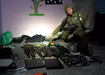El portavoz de las FDI, Daniel Hagari, con las armas encontradas por las fuerzas de las FDI en un centro de mando de Hamás bajo el hospital Rantisi de la ciudad de Gaza, en una foto difundida por el ejército el 13 de noviembre de 2023. (Fuerzas de Defensa de Israel)