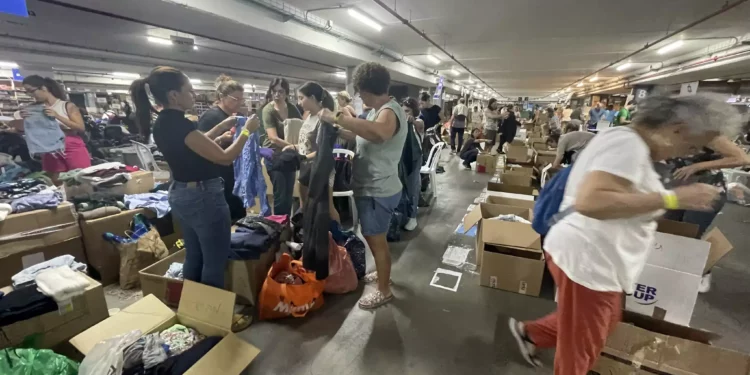 Voluntarios ayudan a clasificar y empaquetar artículos donados en el Centro de Operaciones Civiles, Expo Tel Aviv, 19 de octubre de 2023. (Sue Surkes/Times of Israel)