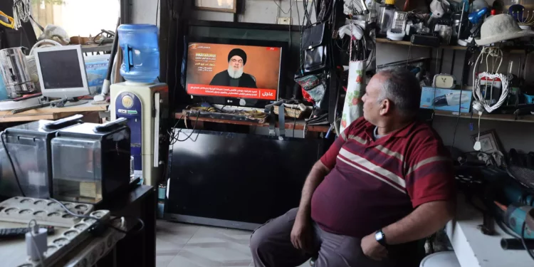 Un hombre sentado en una tienda observa el discurso televisado del jefe de Hezbolá en Líbano, Hasan Nasralá, en la ciudad cisjordana de Tubas el 3 de noviembre de 2023 (Jaafar ASHTIYEH / AFP).
