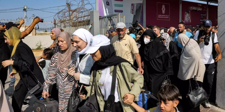 La gente camina a través de una puerta para entrar en el paso fronterizo de Rafah a Egipto en el sur de la Franja de Gaza el 1 de noviembre de 2023 (Mohammed ABED / AFP)