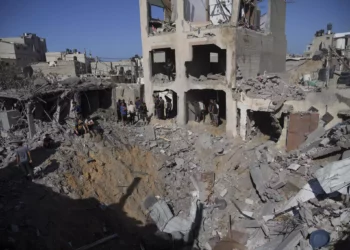 Palestinos observan edificios destruidos en un ataque israelí en Deir al Balah, Franja de Gaza, 7 de noviembre de 2023. (Hatem Moussa/AP)