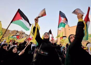 Simpatizantes del grupo terrorista chií libanés Hezbolá ondean banderas mientras ven un discurso televisado del líder Hassan Nasrallah (no se ve) en los suburbios del sur de la capital libanesa, Beirut, el 3 de noviembre de 2023. (Ahmad Al-Rubaye/AFP)