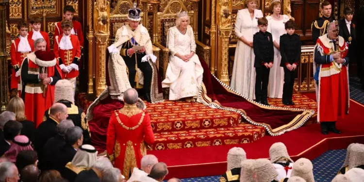 El Rey Carlos III de Gran Bretaña, con la Corona Imperial de Estado y la Túnica de Estado, se sienta junto a la Reina Camilla de Gran Bretaña, con la Diadema de Estado Jorge IV, mientras lee el discurso del Rey desde el Trono Soberano en la Cámara de los Lores, durante la Apertura de Estado del Parlamento, en las Casas del Parlamento, en Londres, el 7 de noviembre de 2023. (Leon Neal / POOL / AFP)