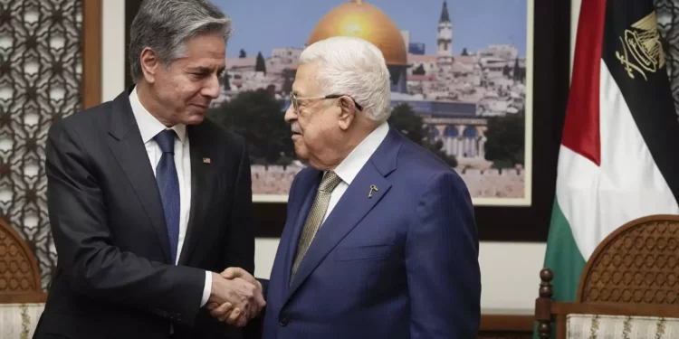 El secretario de Estado de Estados Unidos, Antony Blinken (izquierda), y el presidente de la Autoridad Palestina, Mahmoud Abbas, se dan la mano durante su reunión en la ciudad de Ramala, el 7 de febrero de 2024. (Mark Schiefelbein/AP)