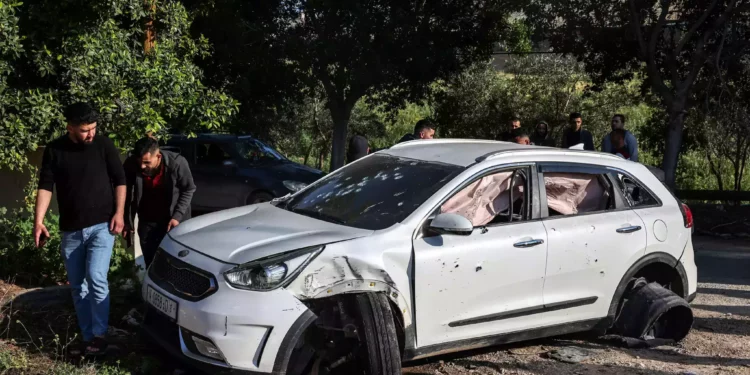 Hombres palestinos revisan un coche acribillado a balazos tras un ataque de las FDI en el campamento de al-Faraa cerca de Tubas, en Judea y Samaria, el 12 de abril de 2024. (Zain Jaafar/AFP)