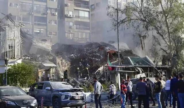 La gente se reúne cerca de un edificio destruido en Damasco, Siria, el 1 de abril de 2024. (SANA vía AP)