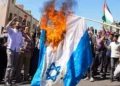 Los manifestantes queman una bandera israelí durante el funeral de siete miembros del Cuerpo de la Guardia Revolucionaria Islámica muertos en un ataque en Siria, del que Irán atribuyó a Israel, en Teherán el 5 de abril de 2024. 

(Foto de ATTA KENARE / AFP)