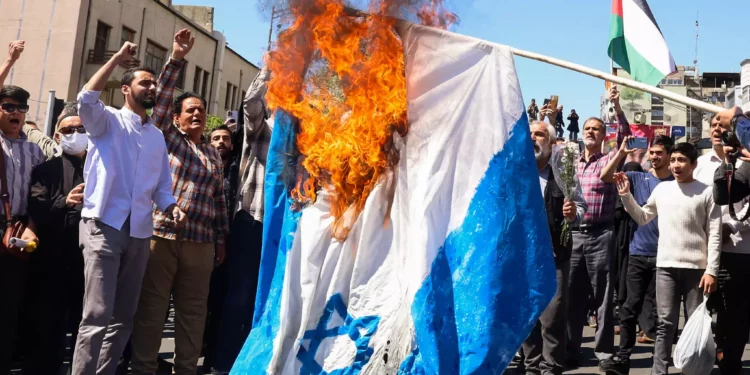 Los manifestantes queman una bandera israelí durante el funeral de siete miembros del Cuerpo de la Guardia Revolucionaria Islámica muertos en un ataque en Siria, del que Irán atribuyó a Israel, en Teherán el 5 de abril de 2024. 

(Foto de ATTA KENARE / AFP)