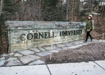 ARCHIVO - Una mujer camina junto a un letrero de la Universidad de Cornell en el campus de la escuela Ivy League en Ithaca, Nueva York, el 14 de enero de 2022. (Foto AP/Ted Shaffrey, archivo)