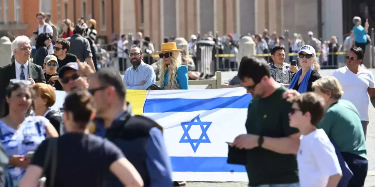 La gente sostiene una bandera nacional israelí en la plaza de San Pedro antes de la oración del Papa Francisco Regina Coeli el 7 de abril de 2024 en el Vaticano. 

(Alberto Pizzoli/AFP)