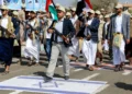 Funcionarios yemeníes armados pisan una bandera israelí mientras participan en un desfile después de 12 días de entrenamiento militar en Saná, la capital gobernada por los hutíes, el 9 de marzo de 2024 (MOHAMMED HUWAIS / AFP)