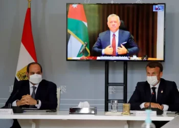 El presidente francés Emanuel Macron (R) y el presidente egipcio Abdel-Fattah el-Sissi asisten a una videoconferencia con el rey Abdullah II de Jordania (en la pantalla) para trabajar en una propuesta concreta para un alto el fuego y un posible camino hacia las discusiones entre Israel y los palestinos en el Palacio del Elíseo en París, el 18 de mayo de 2021. (SARAH MEYSSONNIER / POOL / AFP)