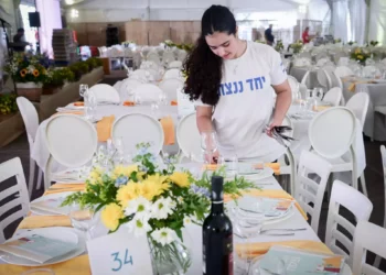 Miembros del kibutz Be'eri ponen la mesa para un Séder de Pésaj en la Plaza de los Rehenes en Tel Aviv. 22 de abril de 2024. (Avshalom Sassoni/Flash90)