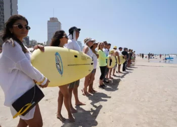 Manifestantes en la playa Gordon de Tel Aviv se unen a una cadena humana que se extiende desde la playa de Habonim hasta Rishon Lezion, para pedir la liberación de los rehenes retenidos desde el 7 de octubre por grupos terroristas en Gaza, el 19 de abril de 2024. (Dana Reany/Movimiento Pro-Democracia)